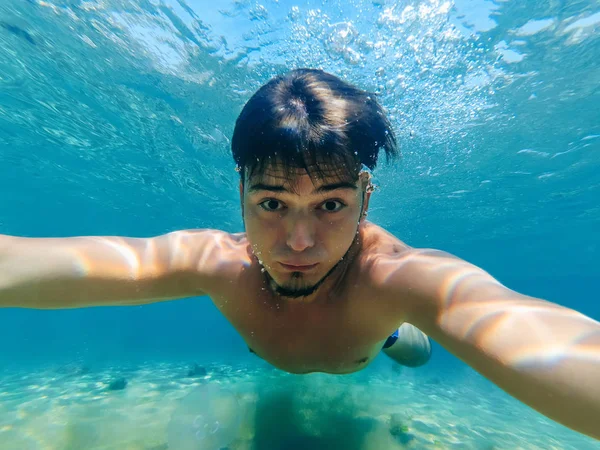 Selfie d'un homme au visage drôle nageant sous l'eau dans la mer — Photo