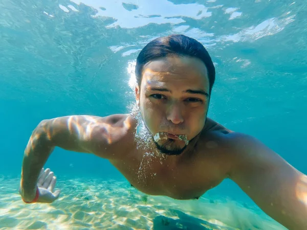 Férfi úszó víz a tenger alatt teszi selfie — Stock Fotó
