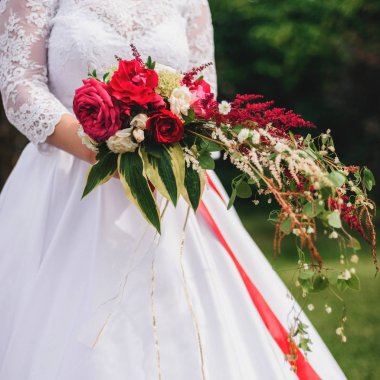 Kırmızı peonies ve yeşil ile düğün buketi gelin elinde bırakır