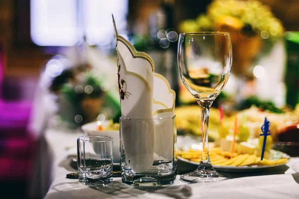 Festive table with wine glasses with napkins and food — Stock Photo, Image