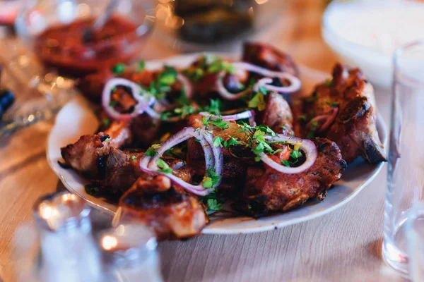 Grilled pork meat on a plate with onions — Stock Photo, Image