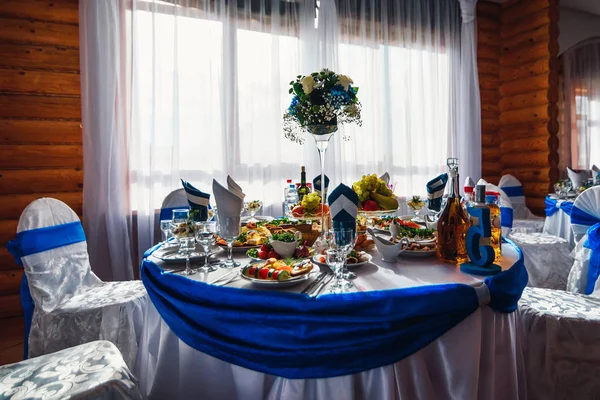 Mesa con comida y bebidas en el restaurante bellamente decorado para una cena de boda festiva —  Fotos de Stock