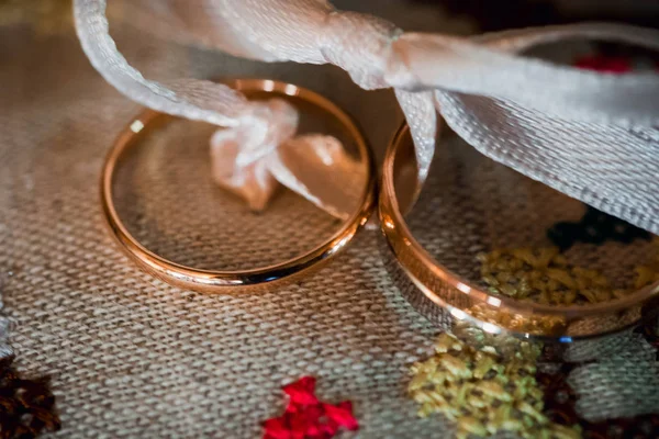 Anéis de casamento de ouro closeup sobre o tecido em um estilo rústico — Fotografia de Stock
