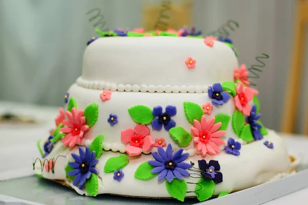 Tort weselny w białej polewie z kwiatami — Zdjęcie stockowe