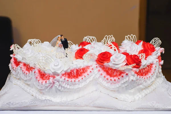 Vit kräm bröllopstårta dekorerad med röda rosor — Stockfoto