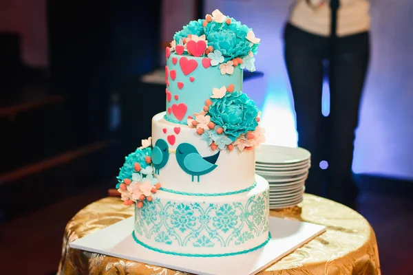 Bolo de casamento com três camadas de esmalte azul branco decorado com flores e corações — Fotografia de Stock