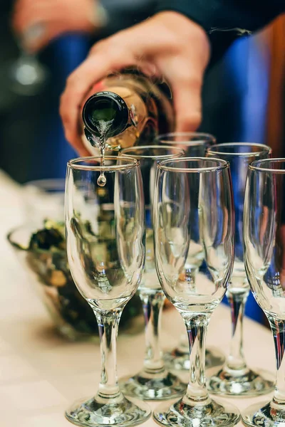 Serveur barman verse champagne d'une bouteille dans des verres — Photo