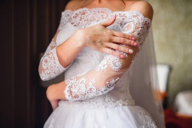 pembe düğün gelinle elinde çivi arka plan üzerinde beyaz bir elbise manikür.