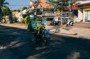 Mui Ne, Vietnam-Circa Mart 2017: yaşlı kadın bir motosiklet sürme ve boş şişeler taşır
