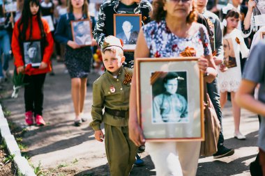 Vichuga, Rusya - 9 Mayıs 2016: Ölümsüz alayın - insanlar onların yakınları, İkinci Dünya Savaşı, zafer günü geçit töreni katılan portreleri ile