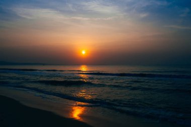 Denizde mavi gökyüzü arka plan üzerinde gündoğumu