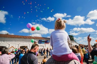 LUH, Rusya - 27 Ağustos 2016: Festival soğan Luh, Rusya'nın köyde. Gökyüzünde uçan balonlar bakarak kız