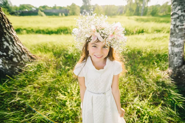 Menina feliz com uma coroa de flores em sua cabeça aparência caucasiana sorrindo — Fotografia de Stock