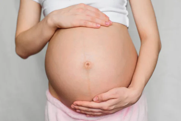 Schwangere umarmt ihren Bauch sanft — Stockfoto