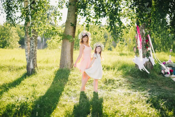 Mamá y su hija posando en el parque en un verano soleado — Foto de Stock