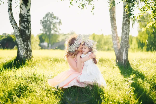 Happy beautiful mother with a daughter of Caucasian appearance hugging in the meadow — Stock Photo, Image