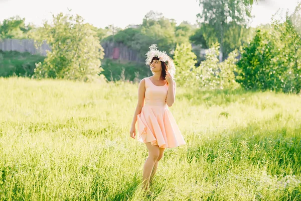 Hermosa chica en un vestido de aspecto caucásico con una corona en la cabeza en un prado — Foto de Stock