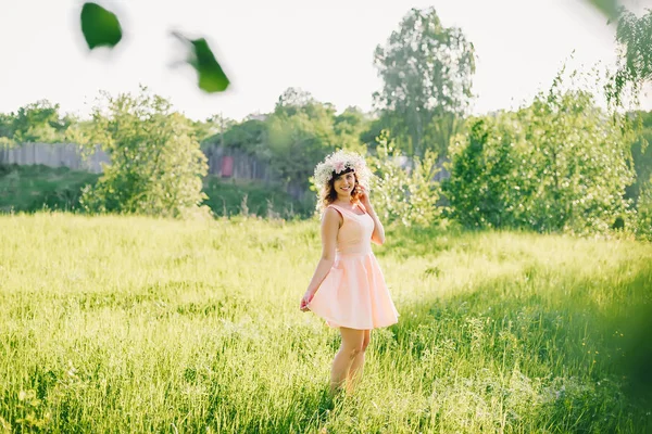 草原の彼女の頭に花輪を捧げると白人外観のドレスを着た美しい少女 — ストック写真