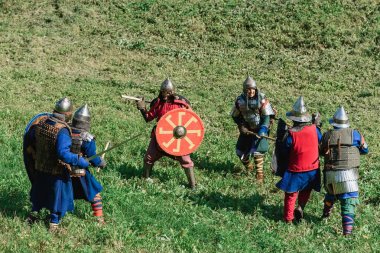 LUH, RUSSIA - AUGUST 27, 2016: Reconstruction of medieval battle of knights in armor and weapons at the festival of Onions clipart