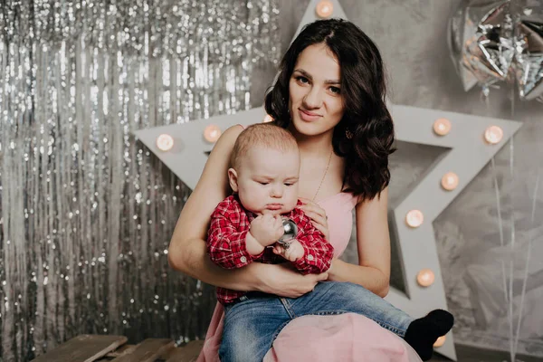 Mamma con neonato bambino figlio tra le braccia sullo sfondo dell'arredamento natalizio — Foto Stock