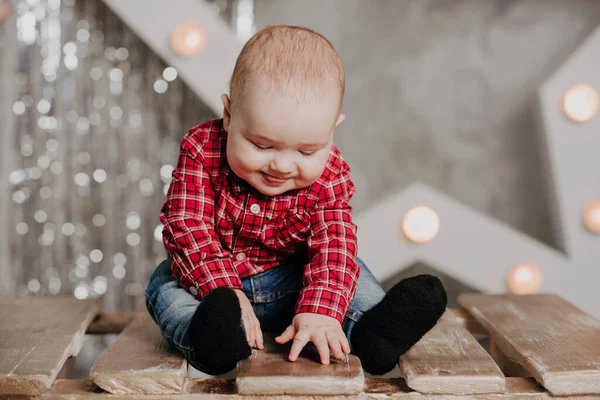 Boldog újszülött fiú ül a háttérben a karácsonyi dekoráció — Stock Fotó