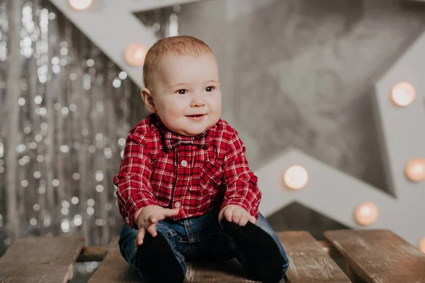 Joyeux garçon nouveau-né souriant assis sur le décor de fond — Photo