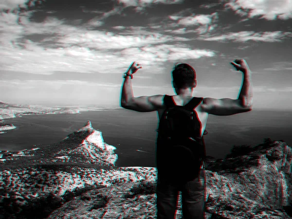 Man reiziger met rugzak staan met zijn rug naar de afgrond van de berg — Stockfoto