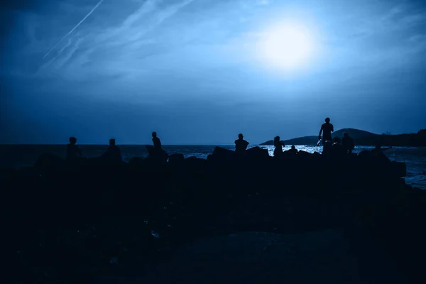 Color del año 2020 azul clásico. Siluetas de personas descansando en el mar —  Fotos de Stock