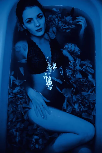 Farbe des Jahres 2020 klassisch blau. Mädchen in der Badewanne mit Blumen — Stockfoto
