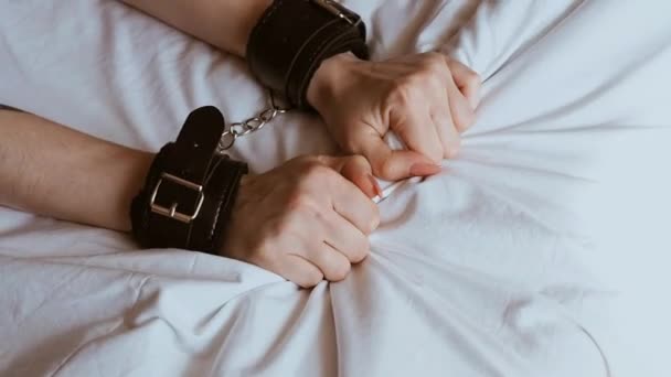 Руки девушек покорны в кожаных наручниках в страстном жестком сексе — стоковое видео