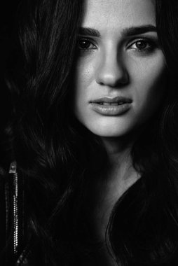 Makyajlı ve uzun saçlı esmer bir kızın portresi.