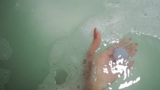 Bomb bath salt dissolves in water and creates foam in womens hands — Stock Video
