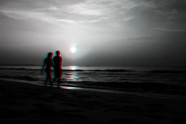 Силуэты влюбленной пары на пляже — стоковое фото