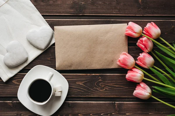 Strauß rosa Tulpen mit einer Tasse Kaffee und weißen Lebkuchen in Herzform zum morgendlichen Frühstück — Stockfoto