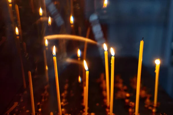 Brandende gele kaarsen in de orthodoxe kerk — Stockfoto