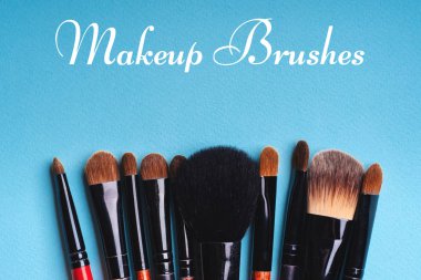 Mavi arka planda makyaj fırçaları