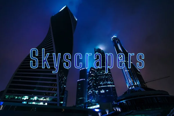 Inscriptie wolkenkrabbers op de achtergrond van hoogbouw — Stockfoto