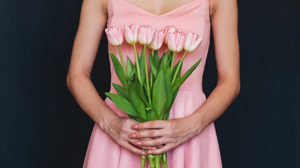 Bukiet różowych tulipanów w rękach dziewczynki — Zdjęcie stockowe