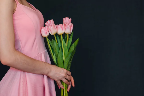 Ramo de tulipanes rosados en las manos de las mujeres — Foto de Stock