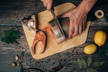 erkek şef tahta bir masada bir Tahta taze kırmızı balık keser