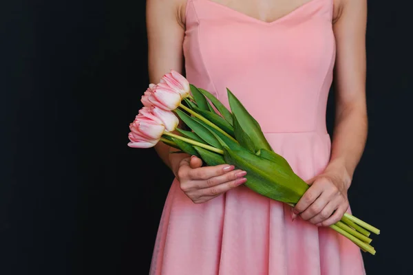 Bukiet różowych tulipanów w rękach kobiet — Zdjęcie stockowe