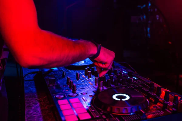 Mãos de um DJ misturando música em um controlador profissional em uma cabine — Fotografia de Stock