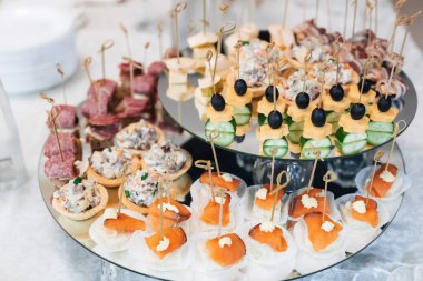 Zeytinli, peynirli, salatalıklı, kırmızı balıklı ve diğer atıştırmalıklı kanepeler.