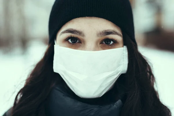 Egy beteg kaukázusi lány portréja orvosi maszkban, hogy védekezzen a vírus ellen egy járvány idején — Stock Fotó