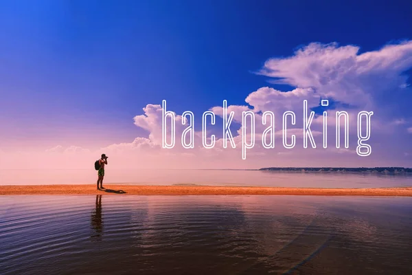 Concept Of Backpacking. A man traveler with a camera and a backpack by the sea — 图库照片
