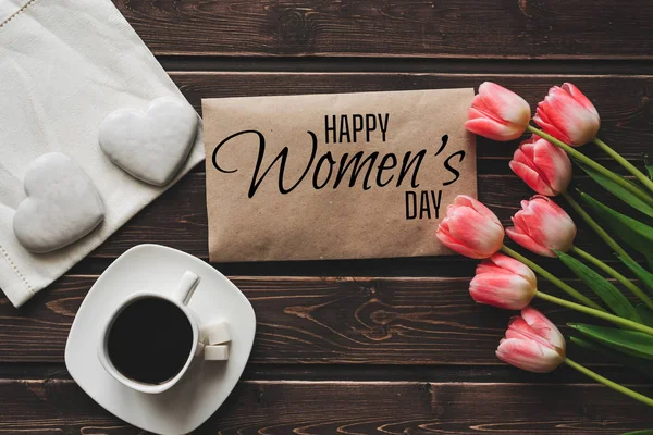 Biglietto di auguri con l'iscrizione Happy Womens Day. Bouquet di tulipani rosa e una tazza di caffè — Foto Stock