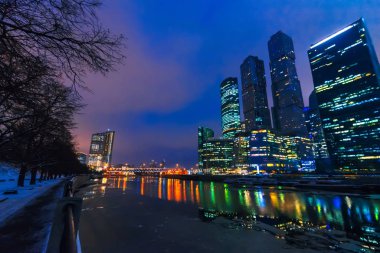 Moskova 'nın gökdelen kuleleri Rus başkentinin nehir kıyısında geceleyin