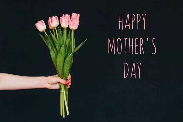 Ευχετήρια κάρτα με την επιγραφή ευτυχισμένη ημέρα μητέρες. Μπουκέτο με ροζ λουλούδια τουλίπας σε γυναικείο χέρι — Φωτογραφία Αρχείου