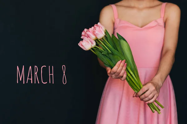 Tarjeta de felicitación con la inscripción 8 de marzo. Ramo de tulipanes rosados en manos de mujeres — Foto de Stock