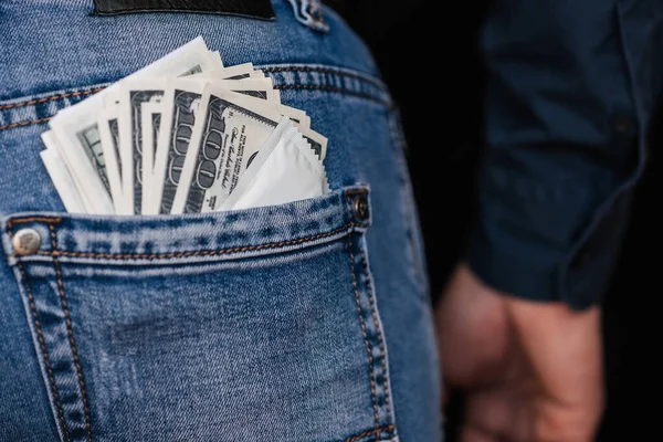 Condom and banknotes money dollars in back pocket men jeans — Stock Photo, Image
